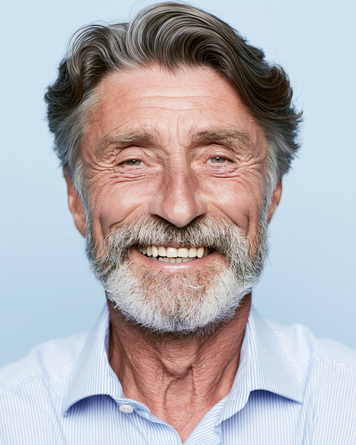 A man with a grey beard, smiling.